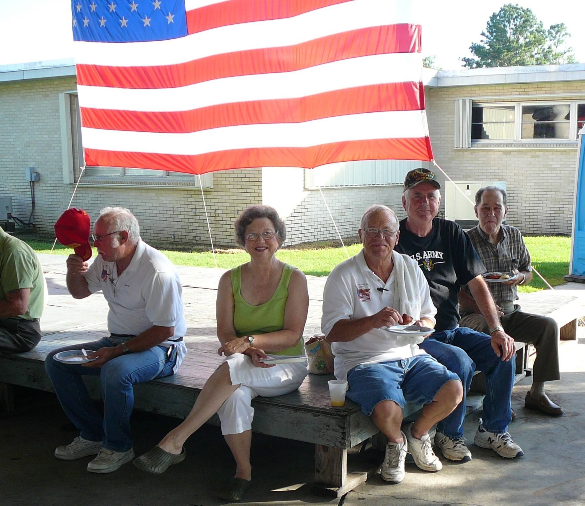 A group of people sitting under an american flag