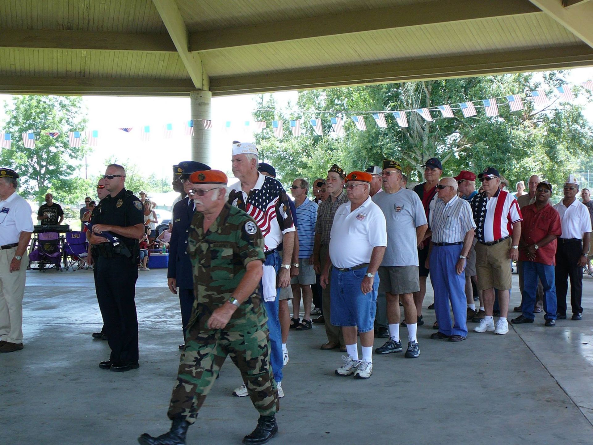 A man in a military uniform is walking in front of a group of men