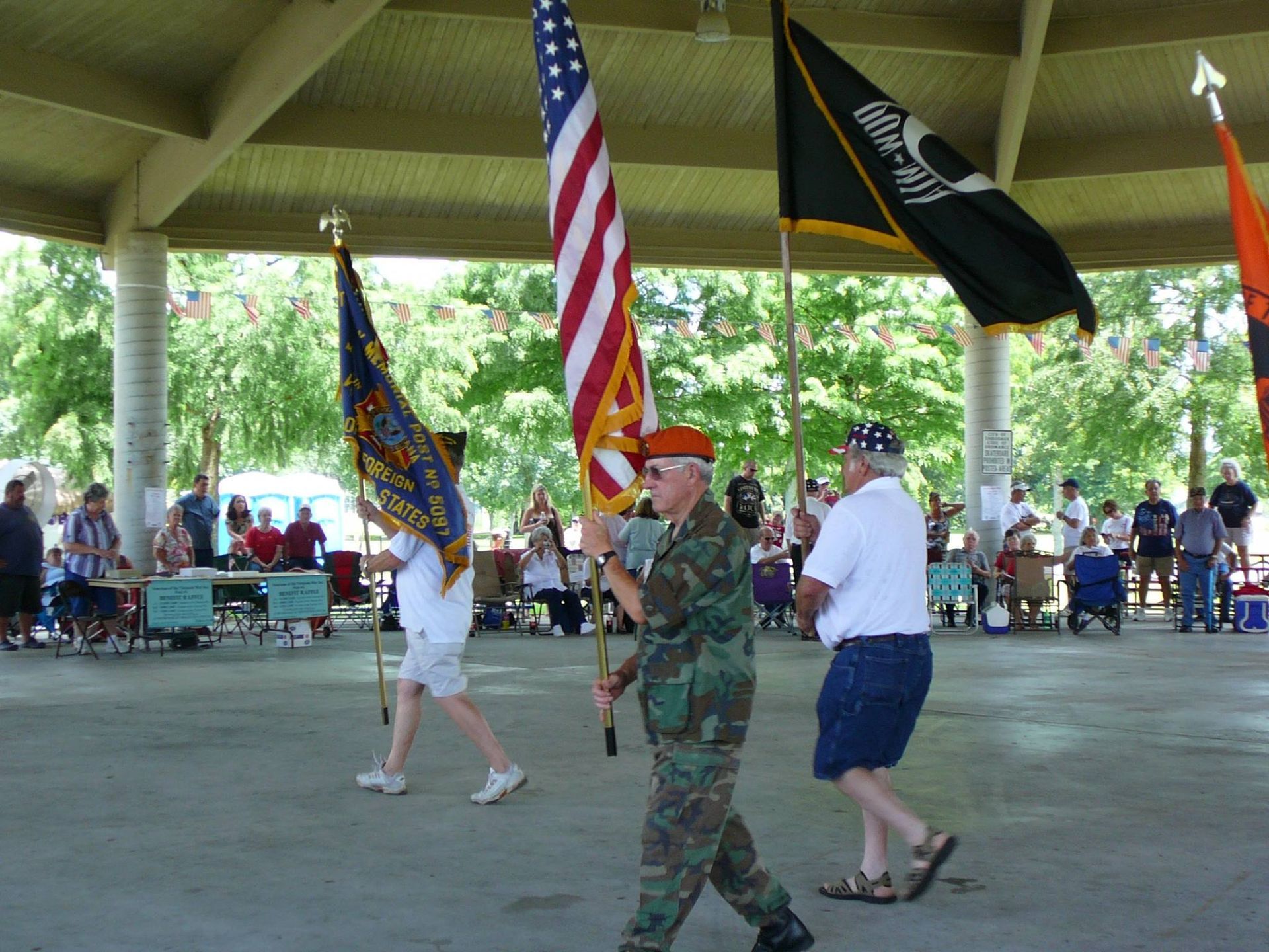 A man in a military uniform carrying an american flag