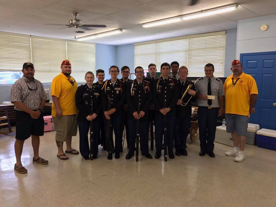 A group of people in military uniforms are posing for a picture in a room.