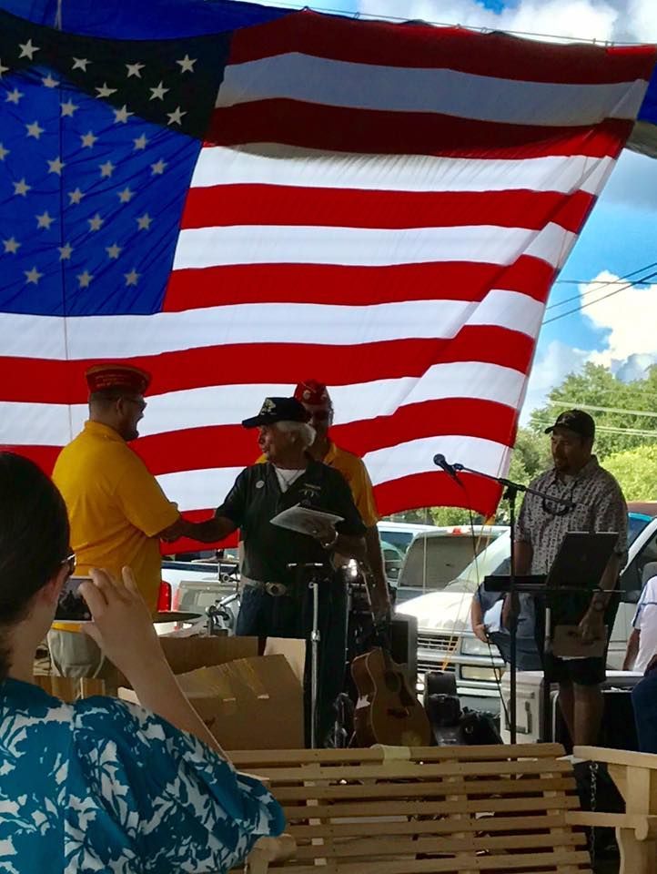 A group of men standing in front of an american flag