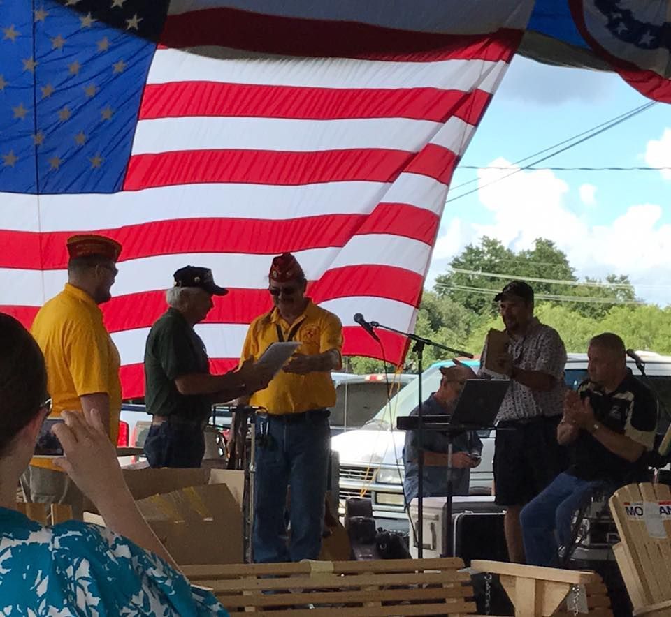 A group of men standing in front of an american flag