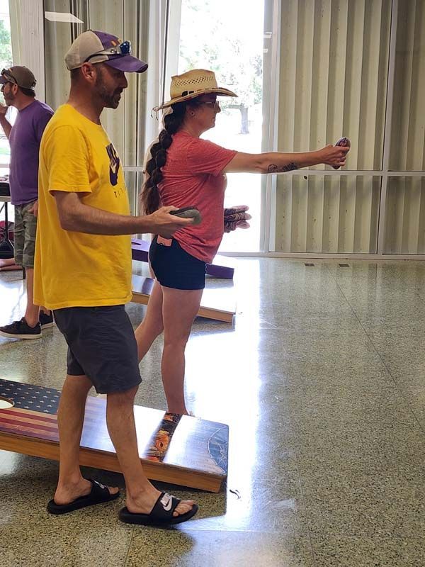 A man in a yellow shirt is standing next to a woman in a red shirt