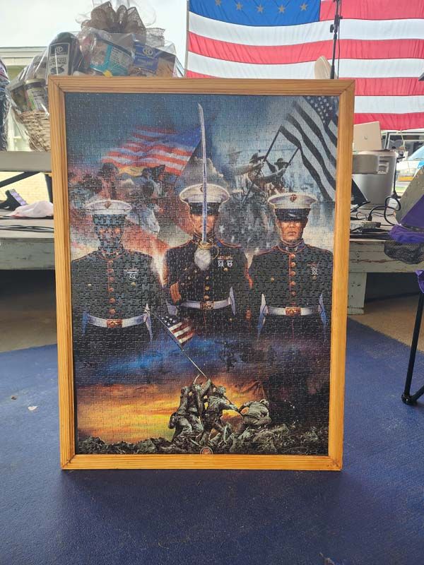 A framed picture of three marines standing in front of an american flag.