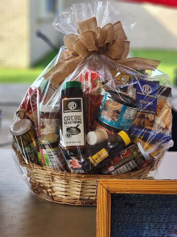 A basket filled with food and a bow is sitting on a table.
