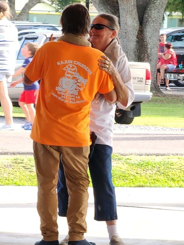 A man wearing an orange shirt that says kansas city on it