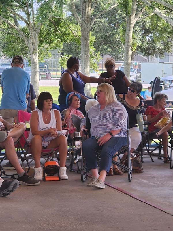 A group of people are sitting in chairs under a pavilion.