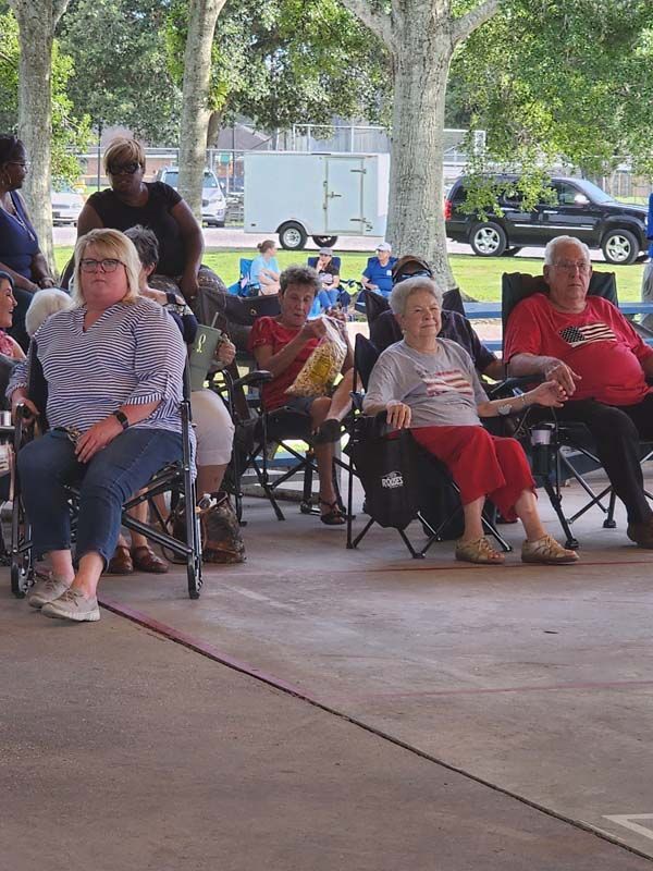 A group of people are sitting in chairs under a canopy.