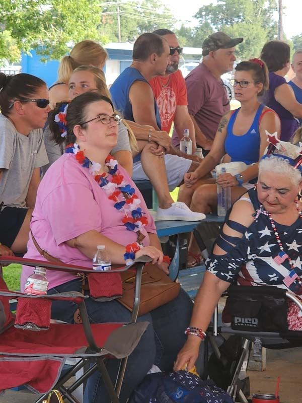 A group of people are sitting in chairs at a park.