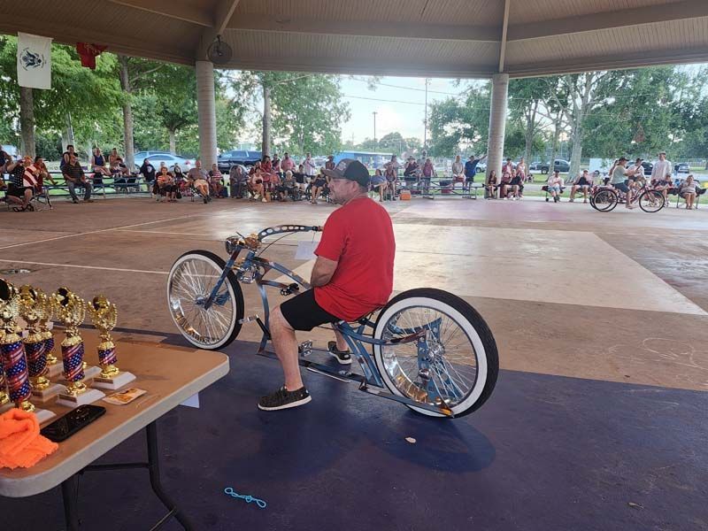 A man in a red shirt is sitting on a bike