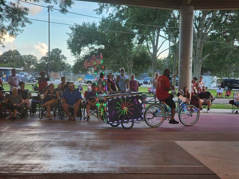 A man is riding a bike in front of a crowd of people