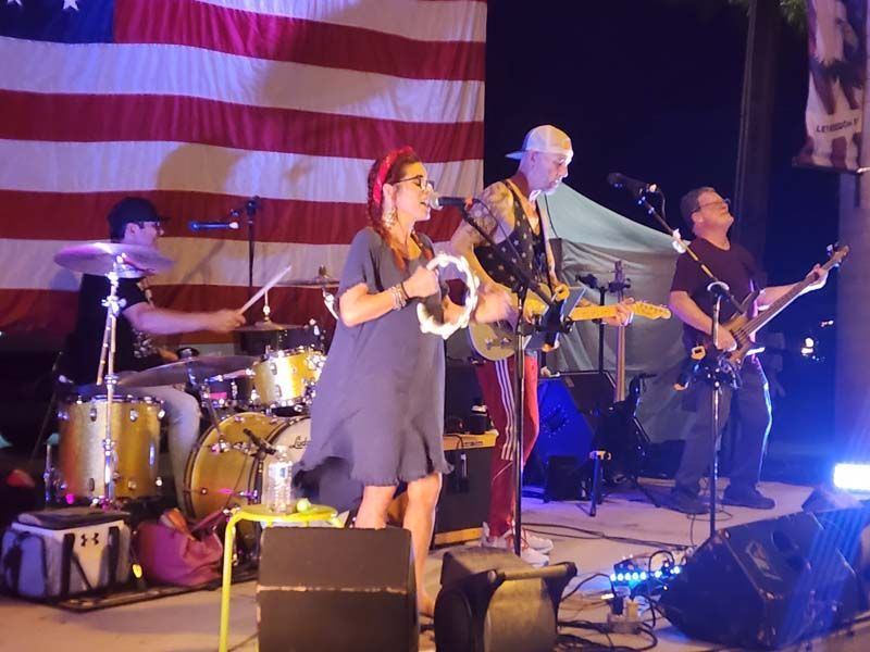 A band is playing in front of an american flag