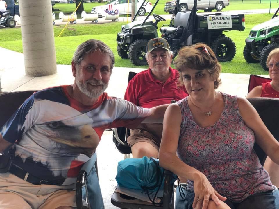 A group of people are posing for a picture while sitting in chairs.
