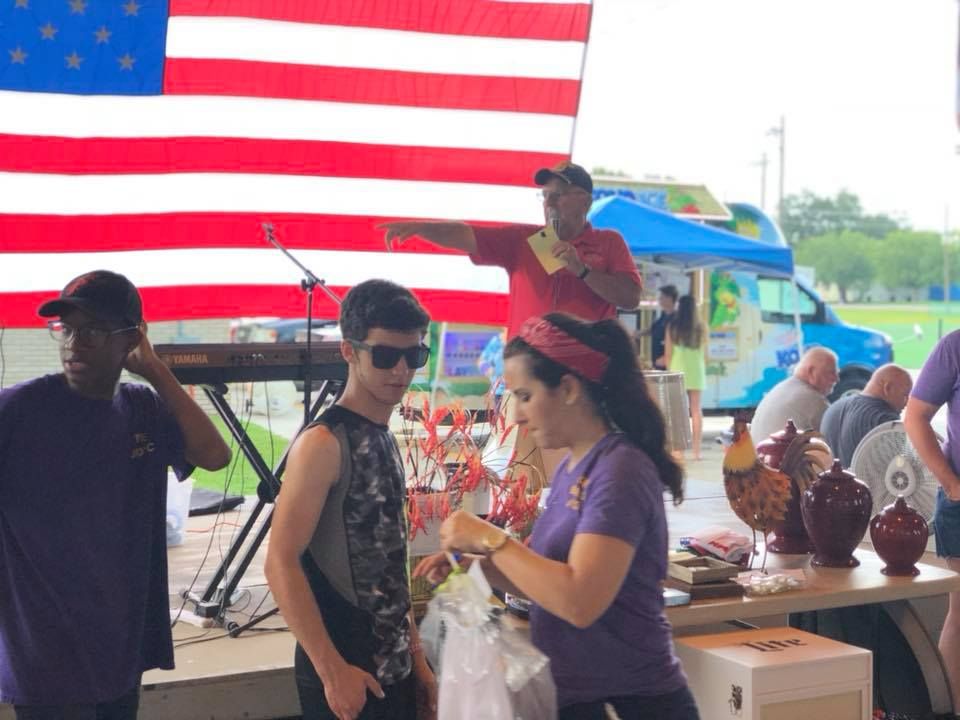A group of people standing in front of an american flag