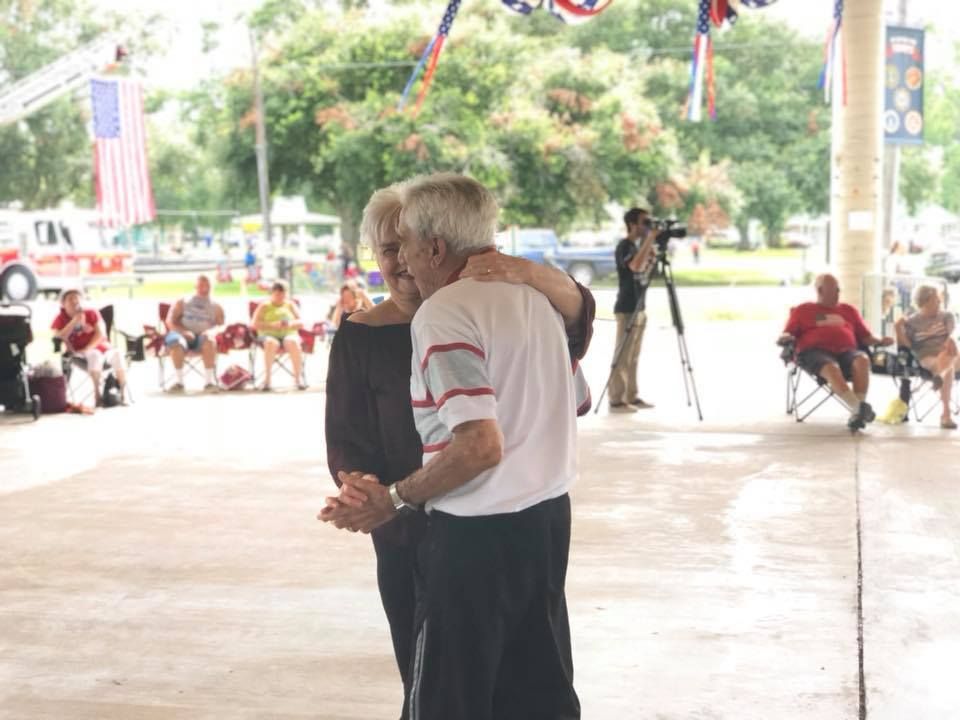 A man and a woman are dancing under a tent