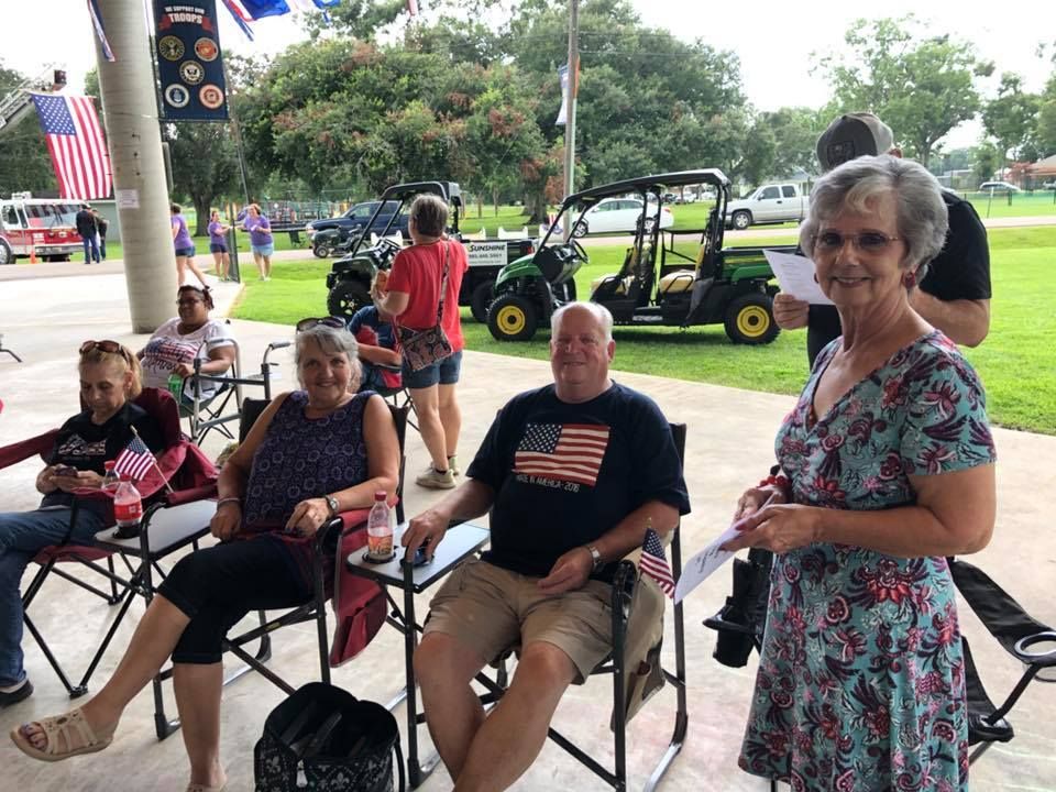 A group of people are sitting in chairs in a park.