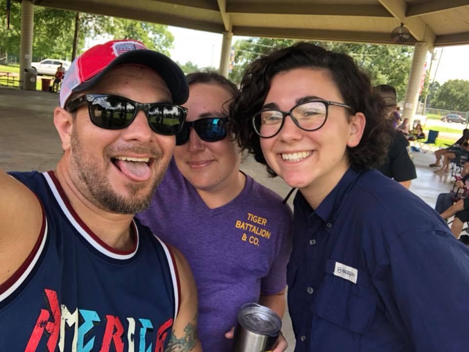 A man wearing a jersey that says america is taking a selfie with two women