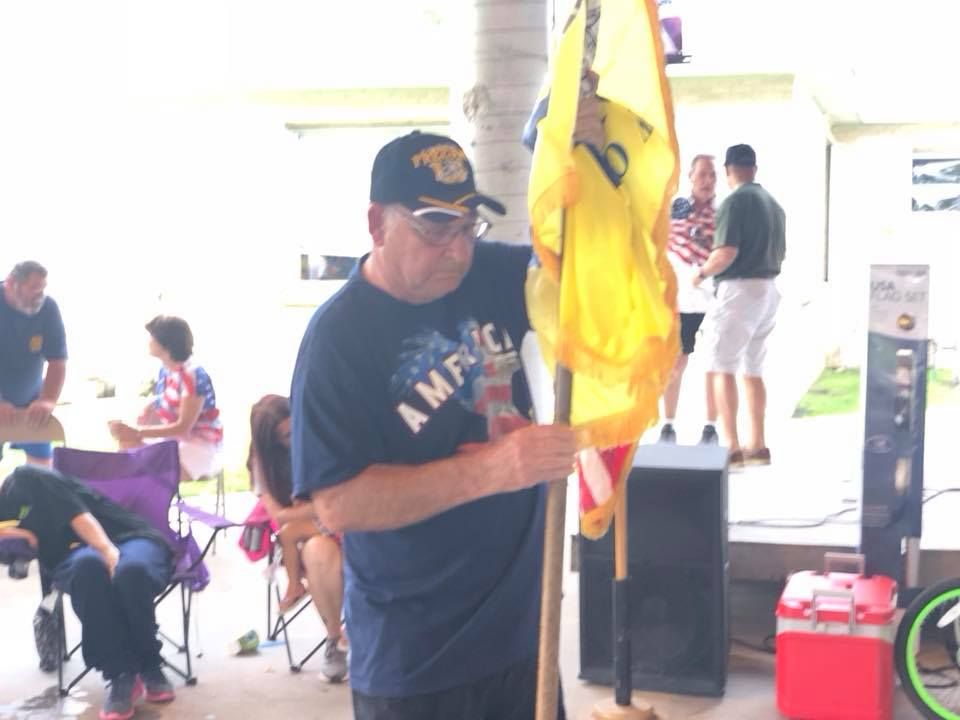 A man wearing a shirt that says america is holding a flag