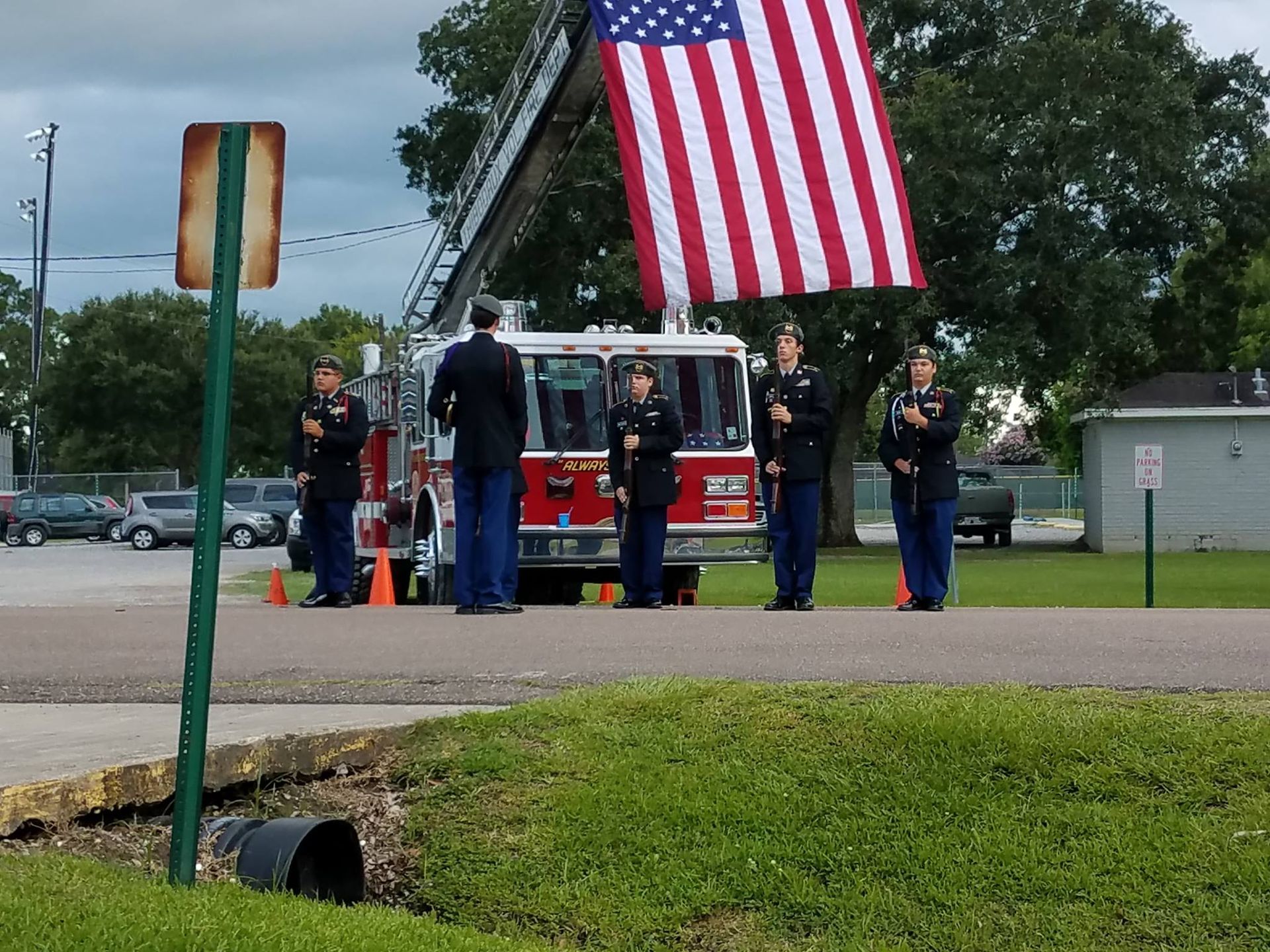 A group of men standing in front of a fire truck holding an american flag
