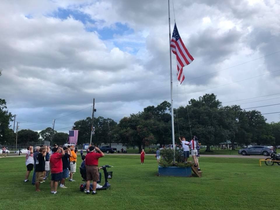 A group of people standing around a flag pole