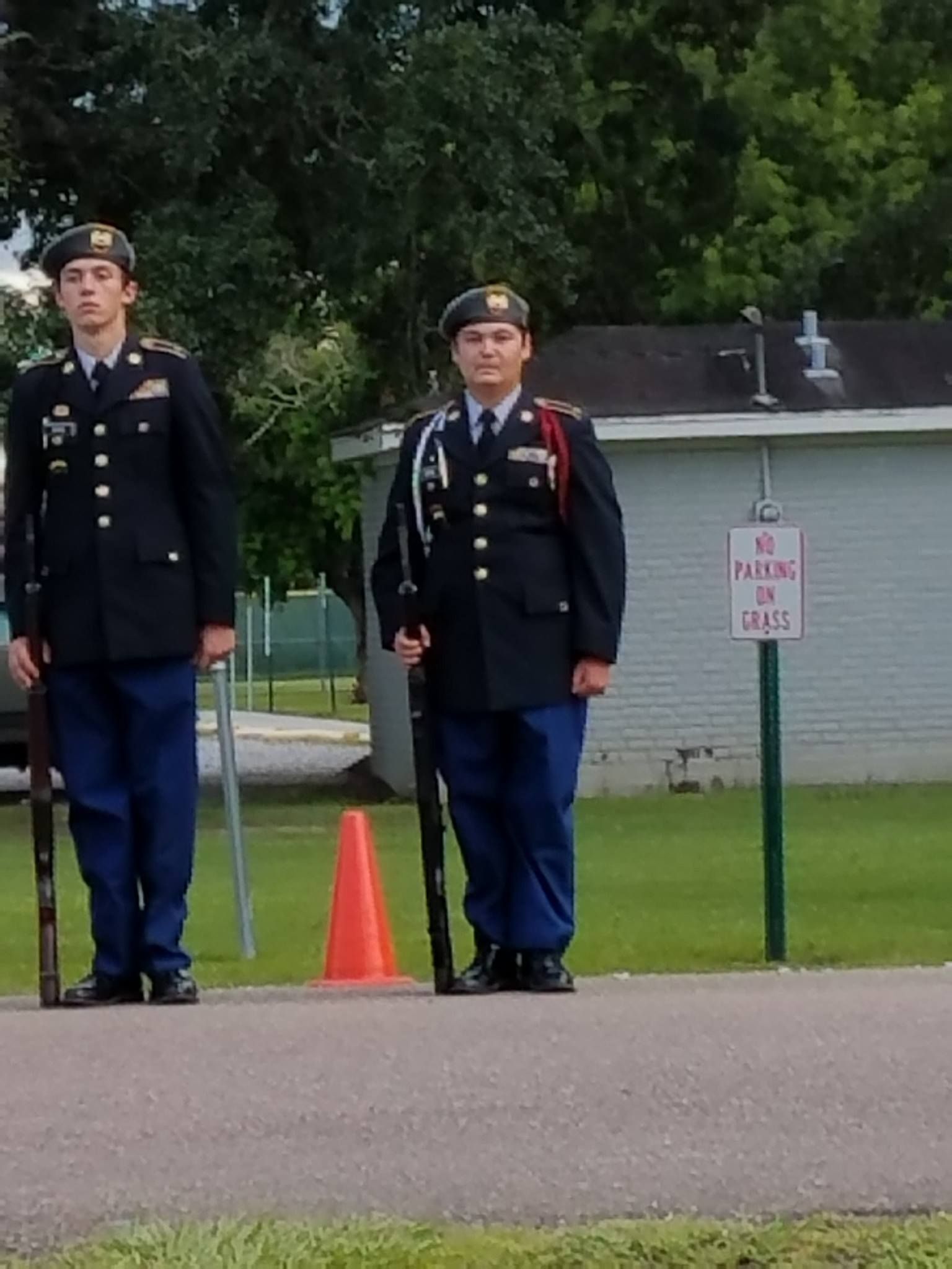 Two soldiers stand in front of a no parking sign