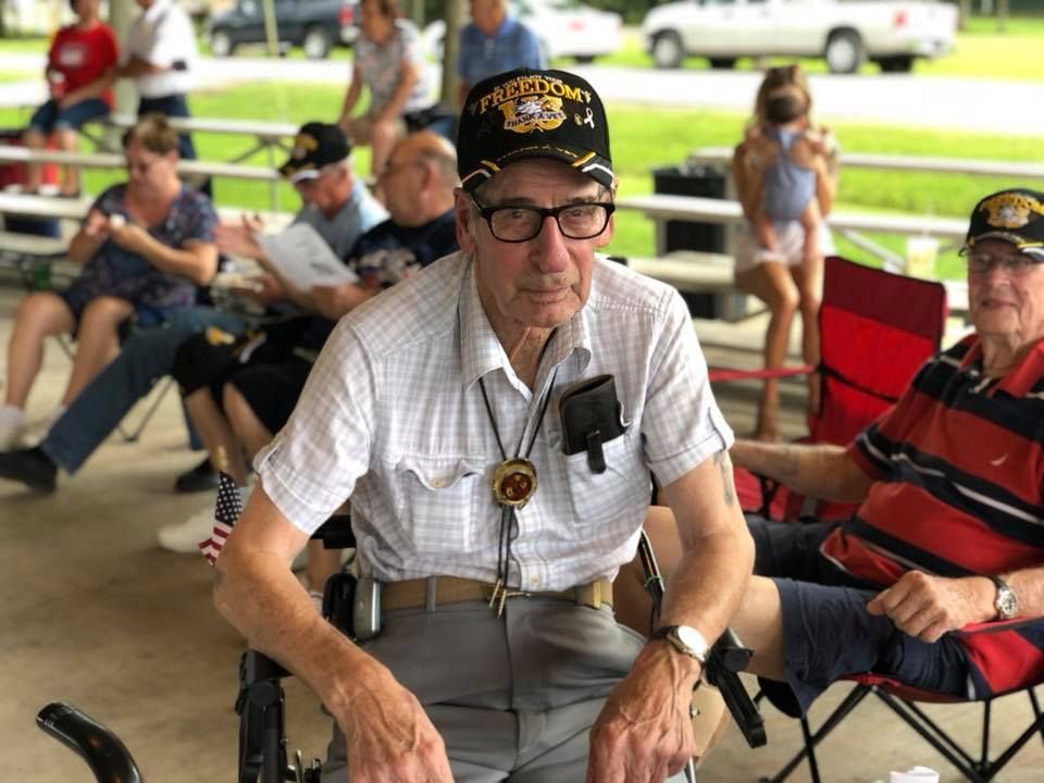 A man in a wheelchair is sitting in front of a crowd of people.