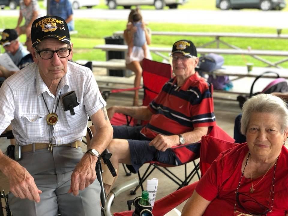 A man in a wheelchair is sitting next to a woman in a red shirt.