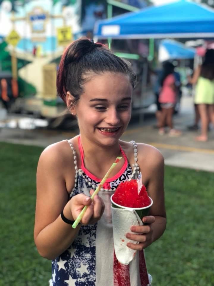 young girl eating a snoball