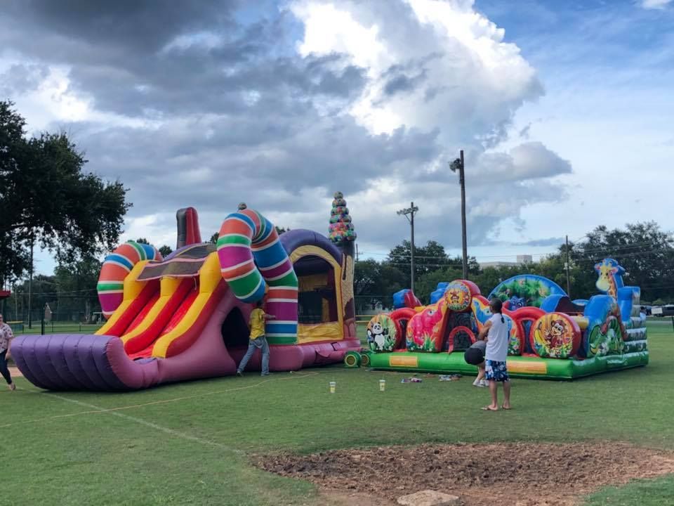 A bunch of inflatable toys are sitting on top of a lush green field.