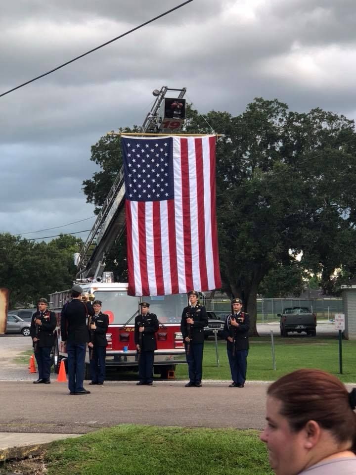 A large american flag is hanging from a fire truck