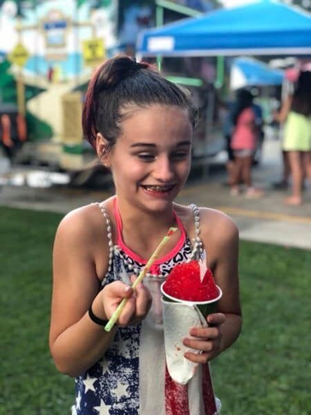 young girl eating a snoball