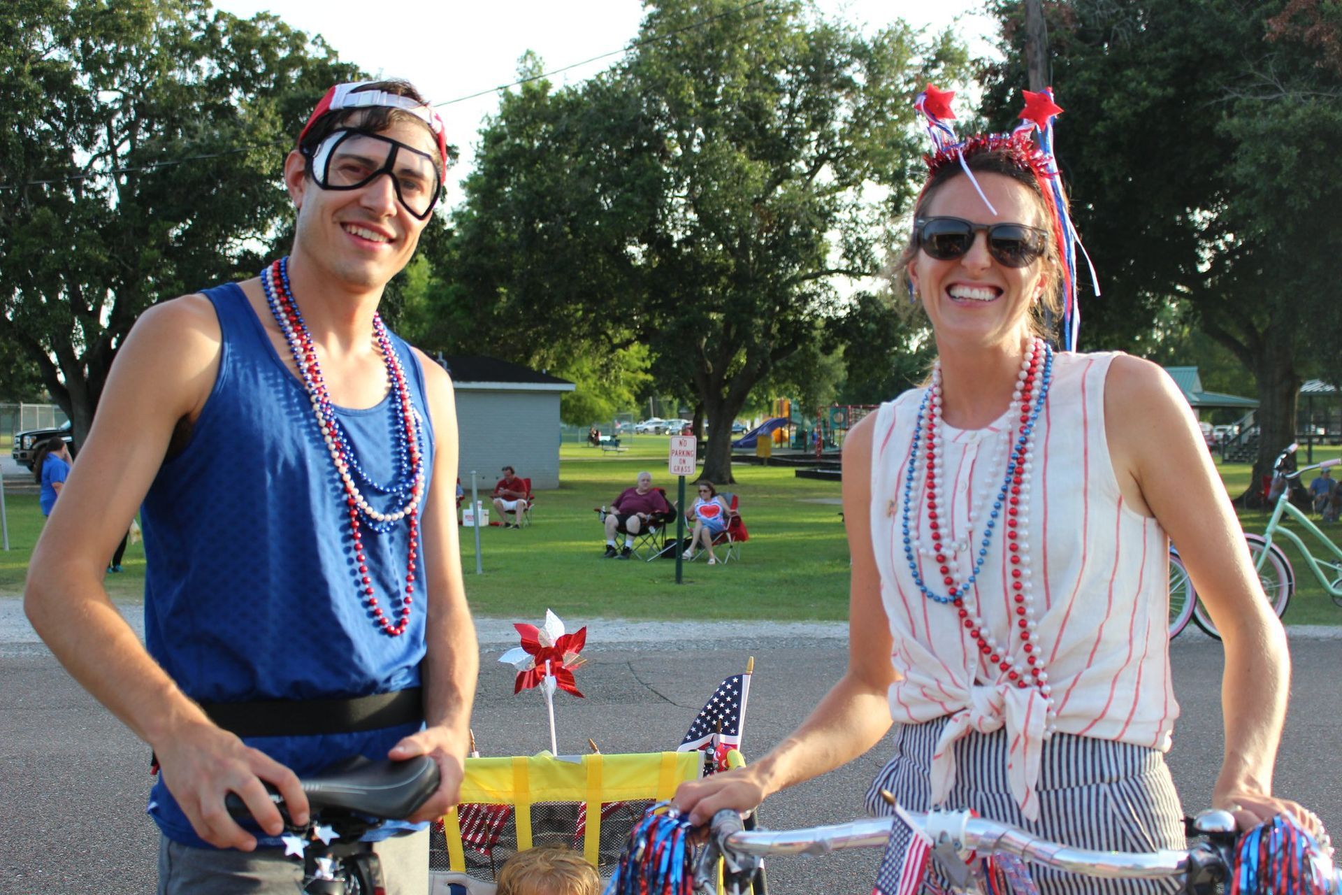 A man and a woman are standing next to each other on a bike.