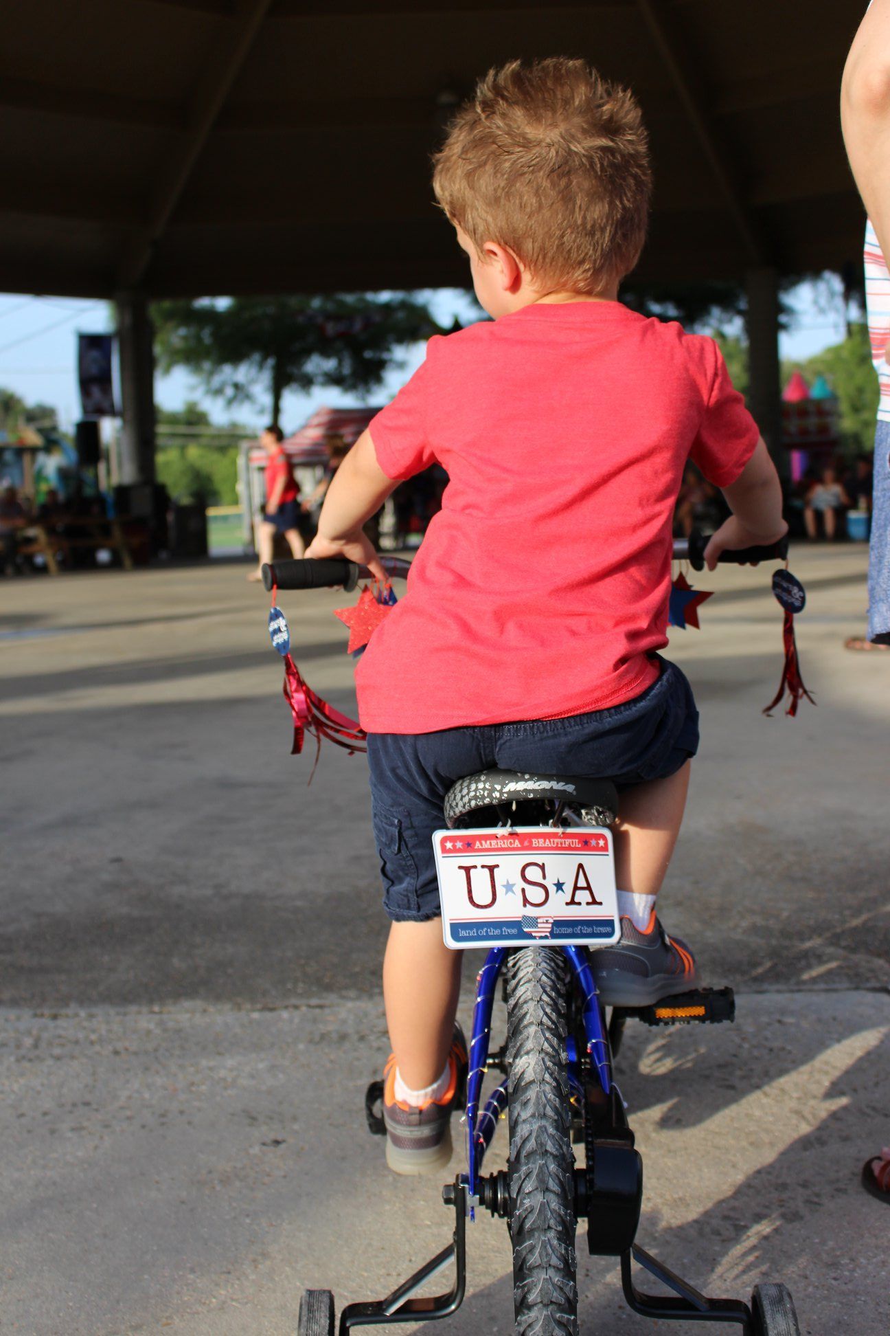 A young boy is riding a bike with a license plate that says u.s.a.