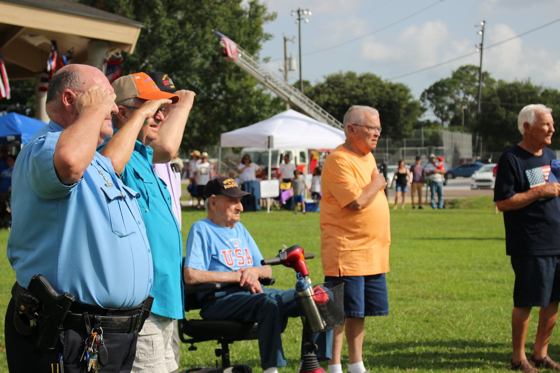 A group of men are standing in a field and saluting