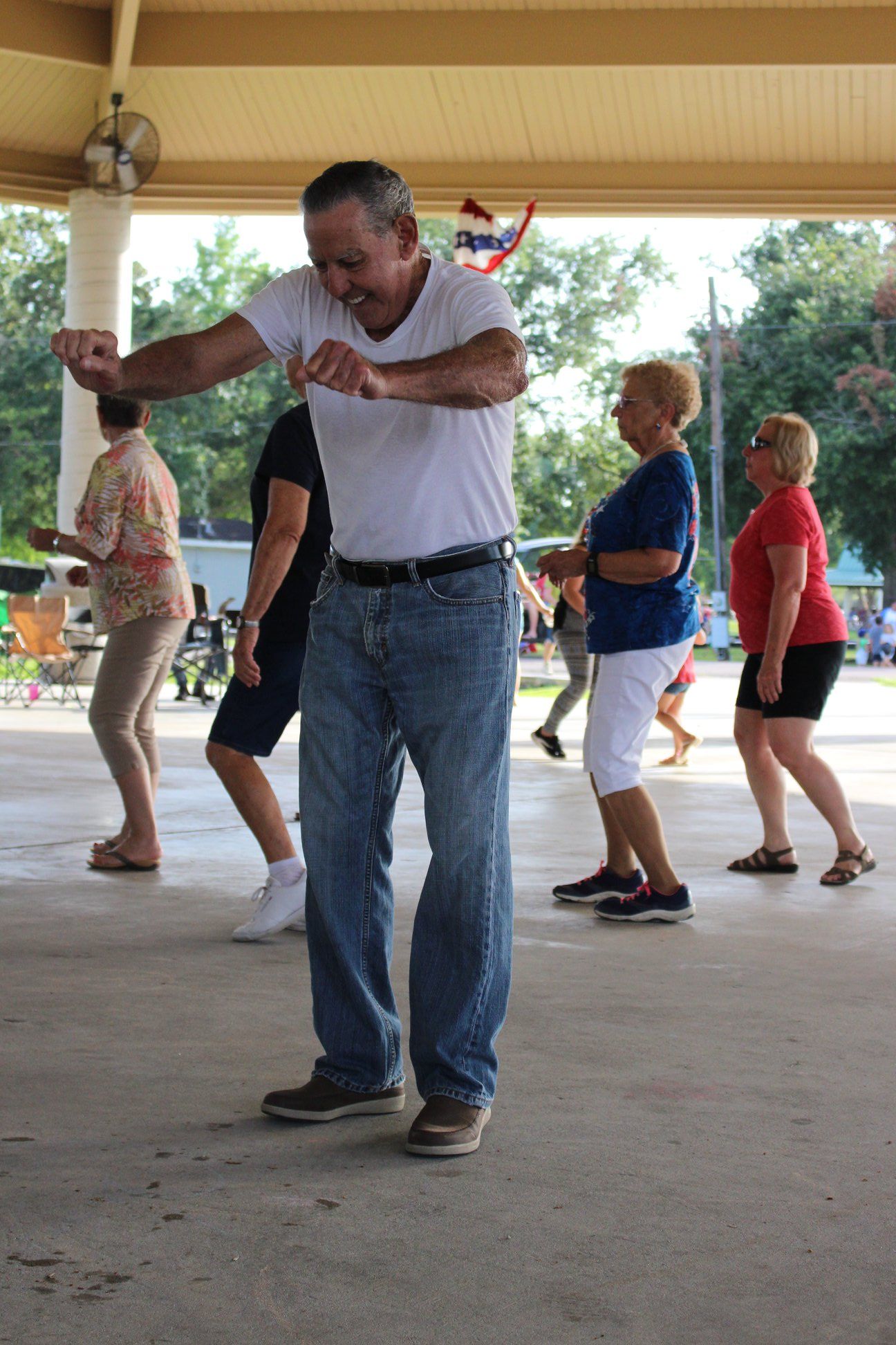 A group of people are dancing under a canopy.