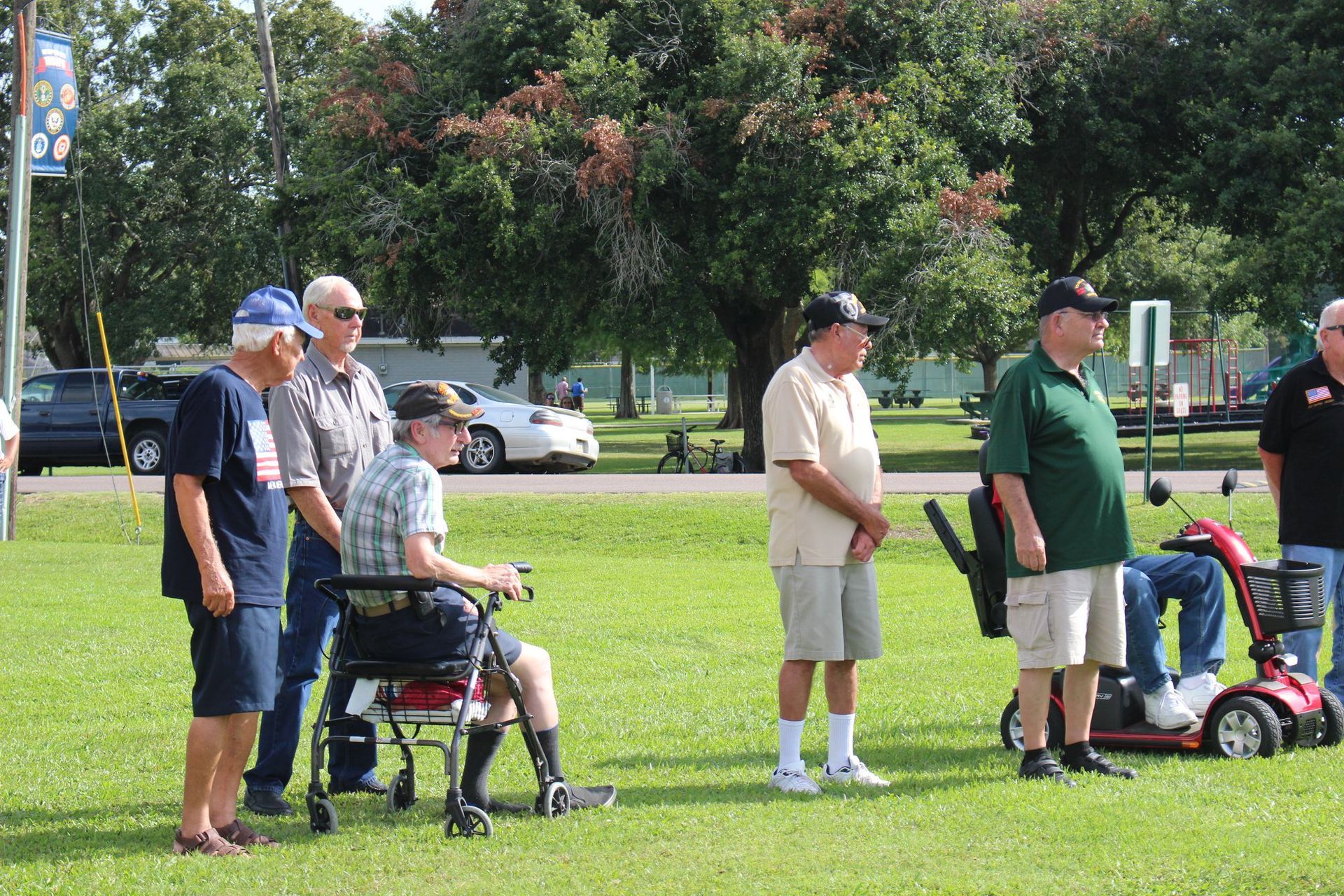 A group of men are standing in a grassy field.