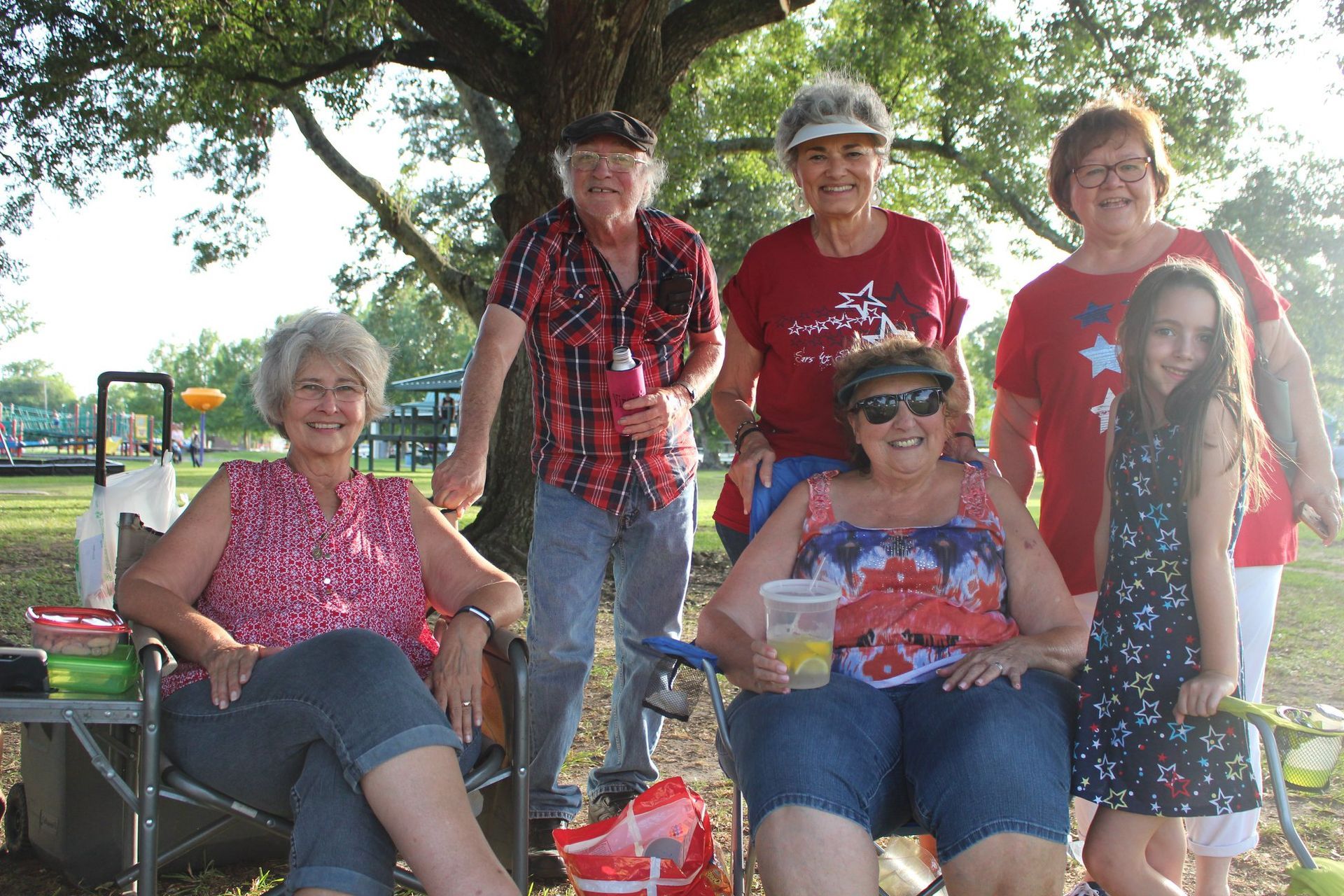 A group of people are posing for a picture in a park.