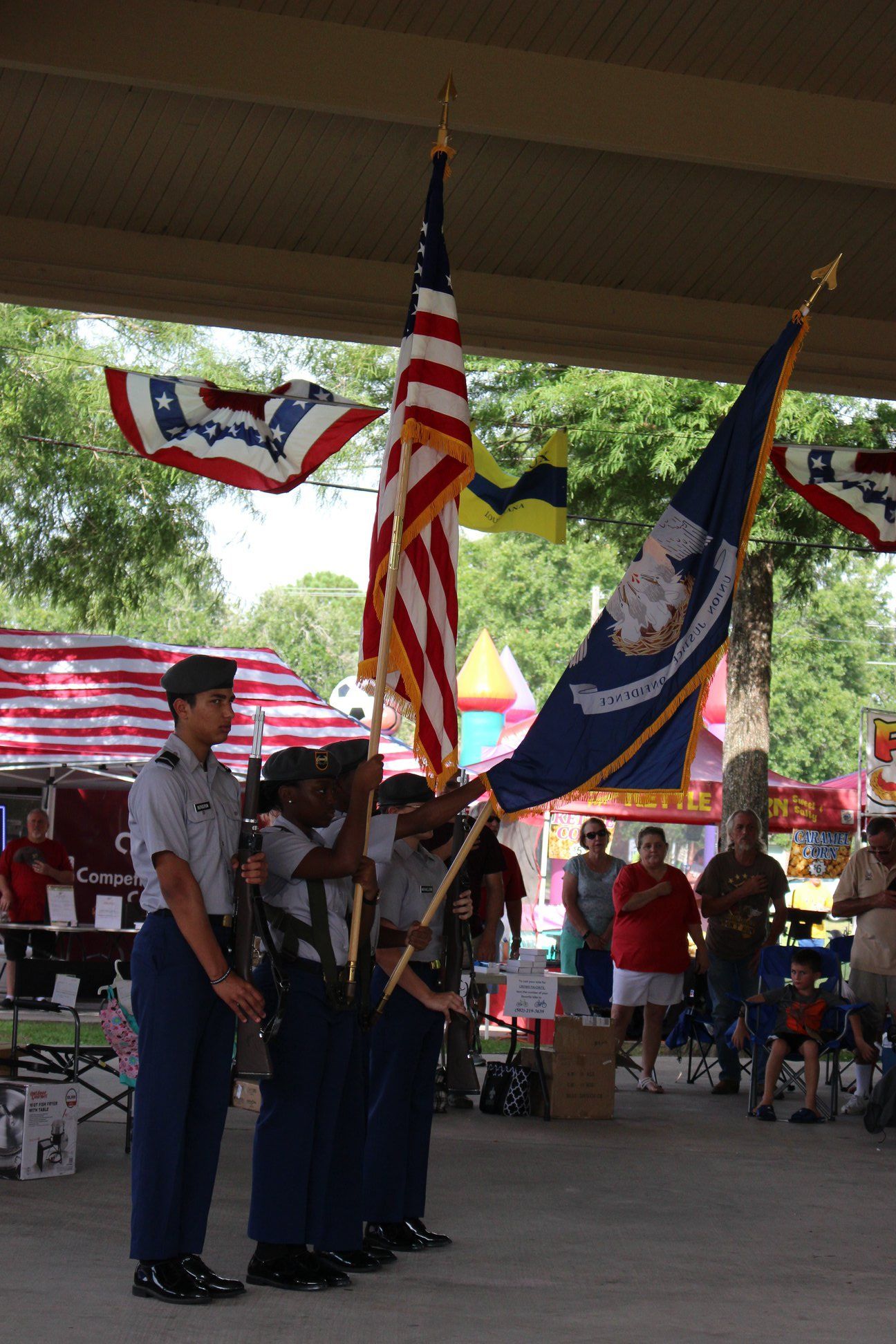A group of soldiers holding american flags in front of a crowd
