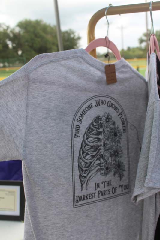 A t-shirt that says find someone who grows together is hanging on a rack