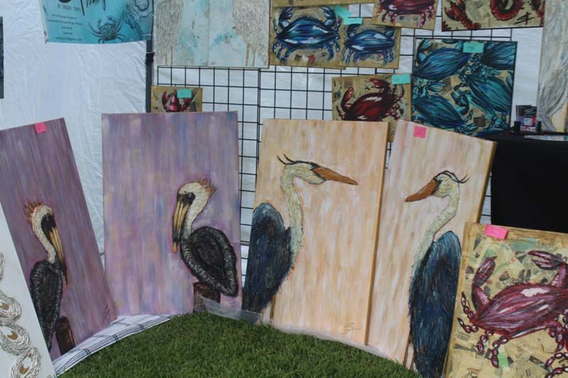 A bunch of paintings of birds and crabs are sitting on a table.