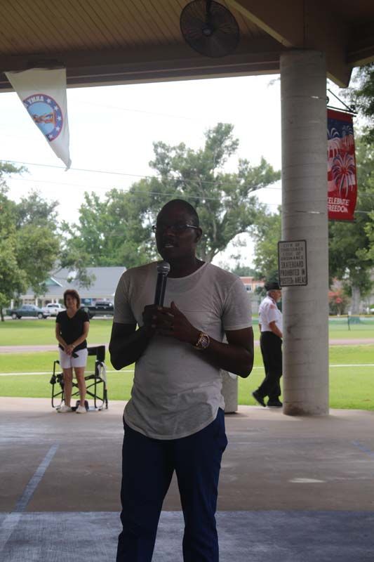 A man in a white shirt is holding a microphone