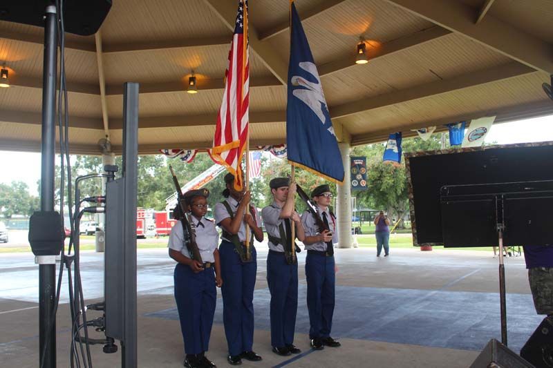 A group of people holding american flags under a canopy