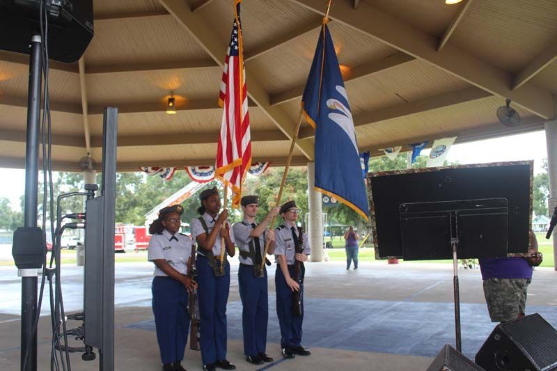 A group of people holding american flags under a pavilion
