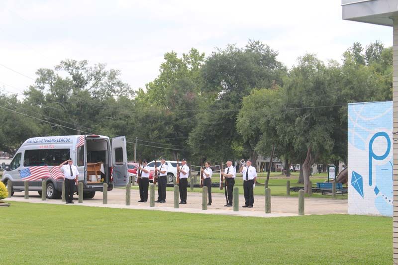 A group of people standing in front of an ambulance.