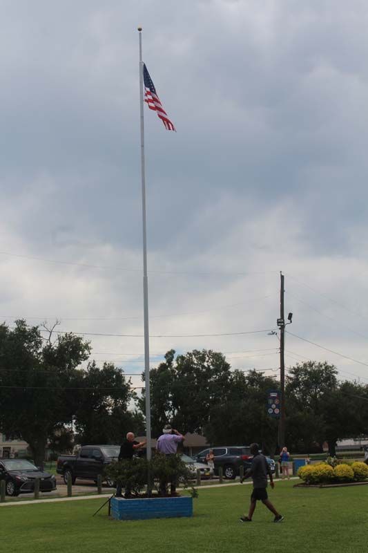 A flag is flying on a pole in a park