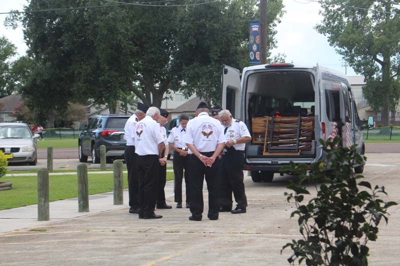 A group of men standing in front of a van that says ' ambulance ' on it