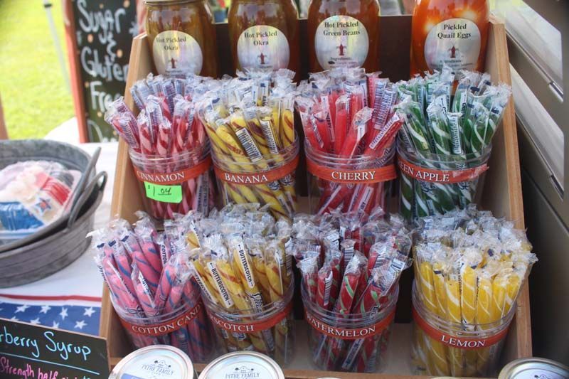 A display of candy sticks and bottles of syrup on a table.