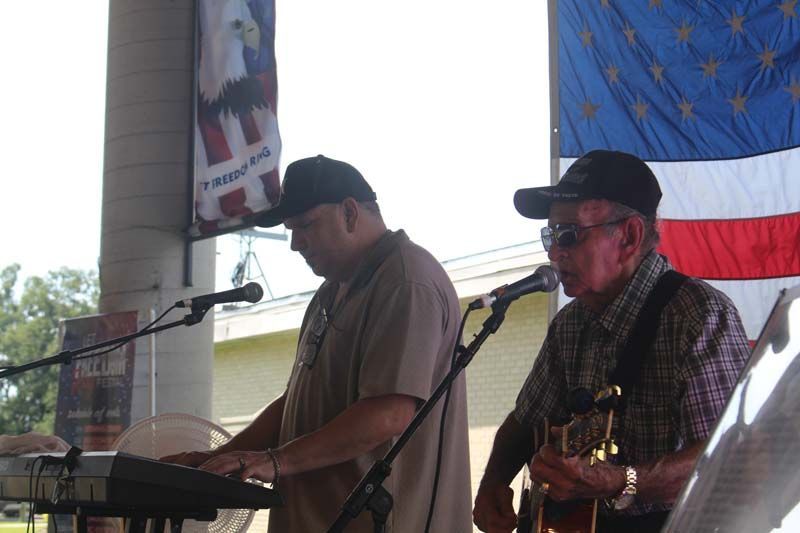 Two men are playing instruments in front of an american flag