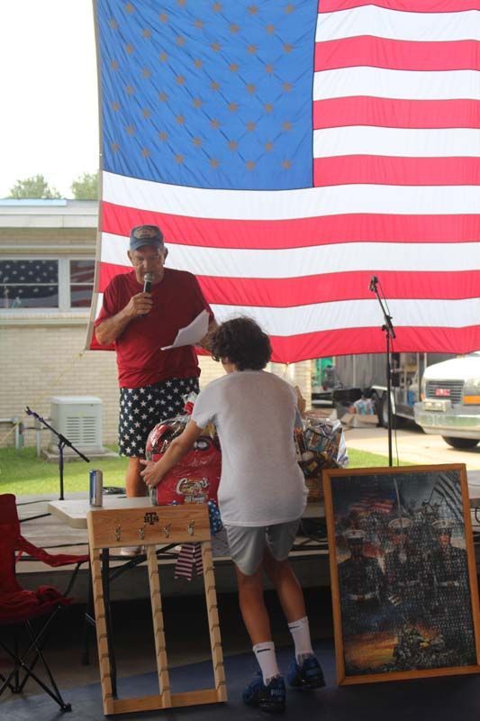 A man is giving a speech in front of an american flag