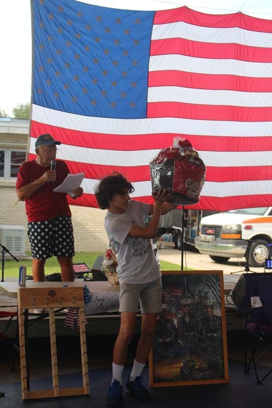A boy is holding a basket in front of an american flag